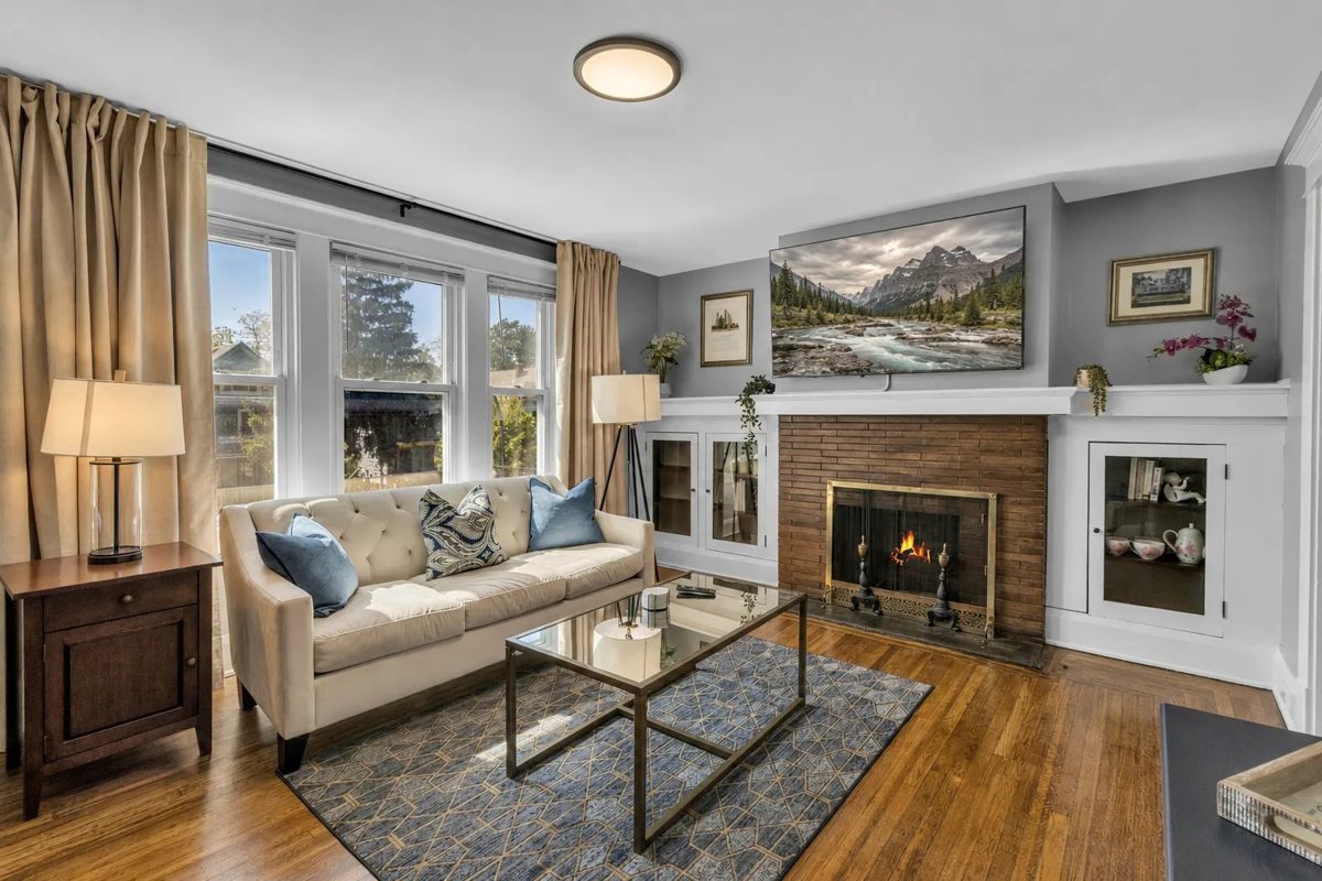 Furnished family room with a fireplace and TV in a Buffalo rental